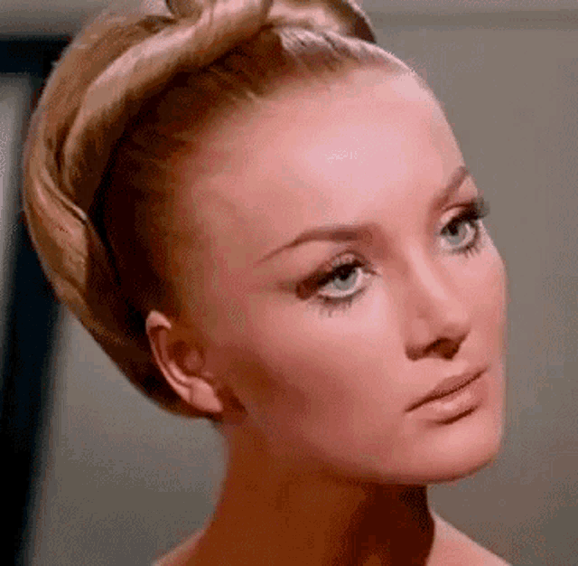 a close up of a woman 's face with blue eyes