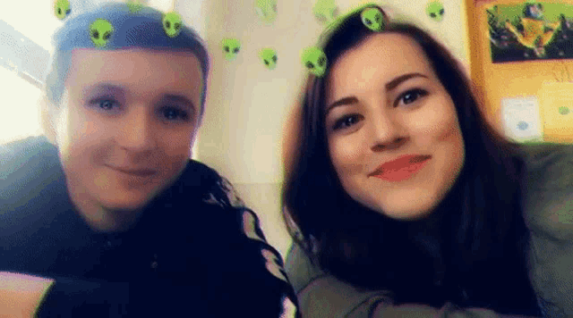 a boy and a girl are posing for a picture with aliens on their faces