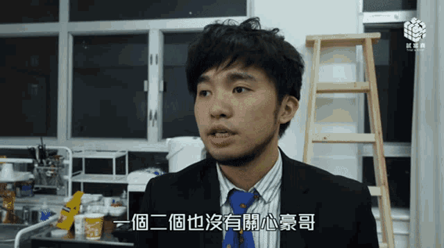 a man in a suit and tie has chinese writing on his shirt