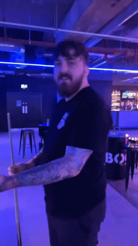 a man holding a pool cue in front of a barrel that says bo