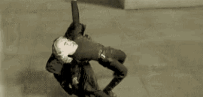 a man is laying on the ground while another man holds him up .