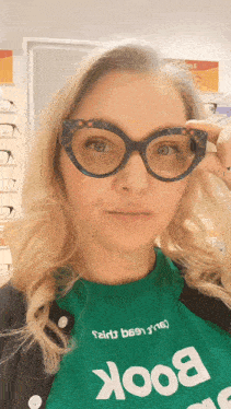 a woman wearing glasses is wearing a green book shirt