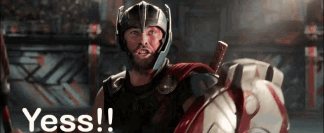 a man in a helmet is holding a shield and a sword and says yess