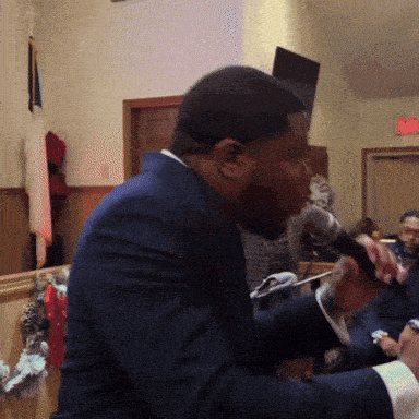 a man in a suit singing into a microphone in a church