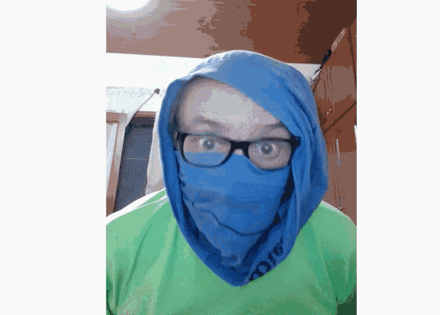 a man wearing glasses and a blue scarf around his neck