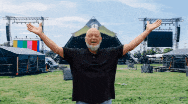 a man with his arms outstretched is standing in front of a stage