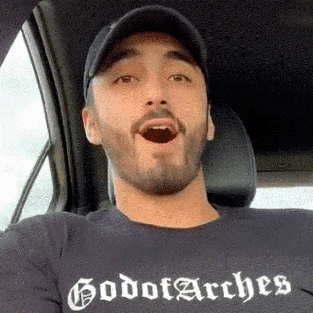 a man with a beard wearing a black shirt that says godot arches