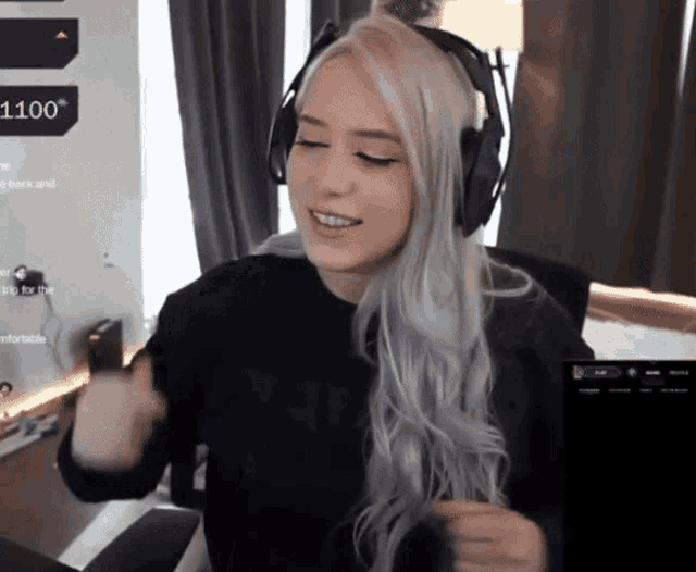 a woman wearing headphones is sitting in front of a screen that says 1100 on it