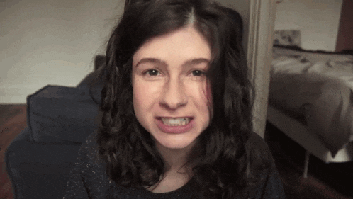 a woman with curly hair is making a face