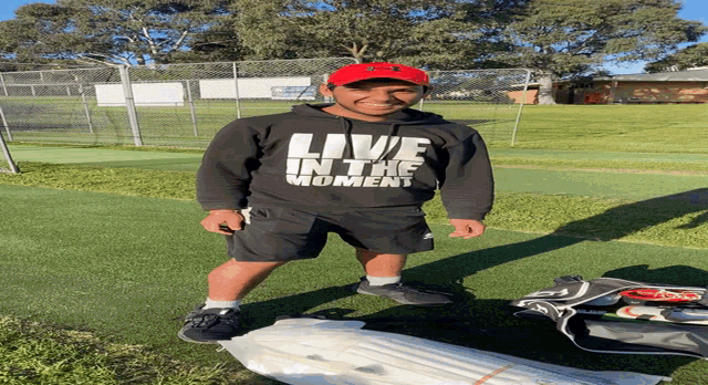 a man wearing a black sweatshirt that says live in the moment