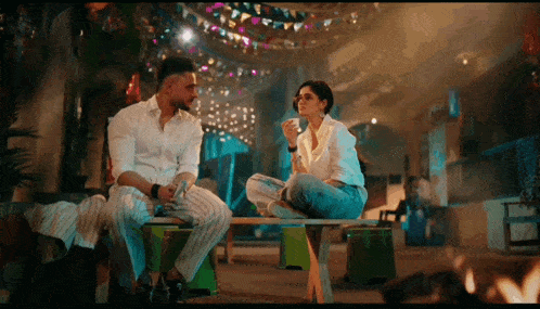 a man and a woman are sitting on a bench and talking