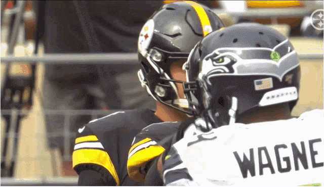 two football players one wearing a wagner jersey are talking to each other