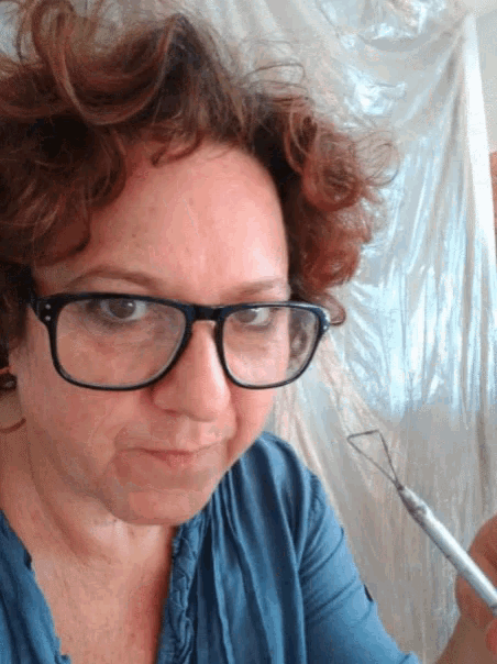 a woman wearing glasses and a blue shirt