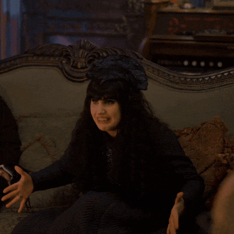 a woman with long hair is sitting on a couch and making a funny face