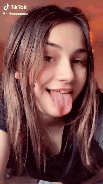 a young woman is sticking her tongue out in a tiktok video