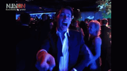 a man and woman are dancing in a dark room with neon written in the corner