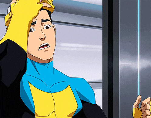 a man in a blue and yellow superhero costume is standing in front of a door