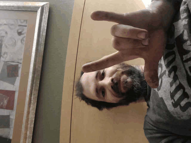 a man with a beard is wearing a shirt that says ' nirvana ' on it