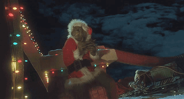 a man in a santa suit is sitting on a sleigh