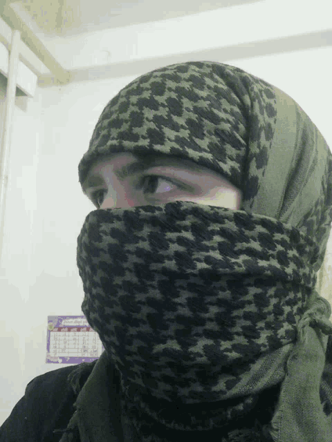 a person covering their face with a scarf in front of a calendar