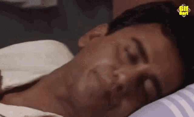 a close up of a man laying down with gif written on the bottom right