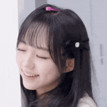 a close up of a girl 's face with a pink hair clip in her hair