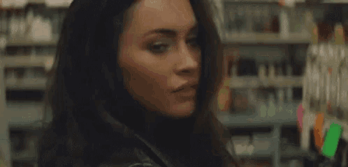 a close up of a woman 's face in a store with a blurred background .