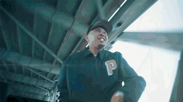 a man wearing a black jacket with the letter p on the sleeve