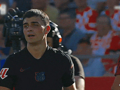 a man wearing a black nike shirt with the letter k on his arm