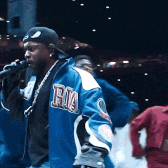 a man singing into a microphone wearing a blue jacket with the letter ria on it