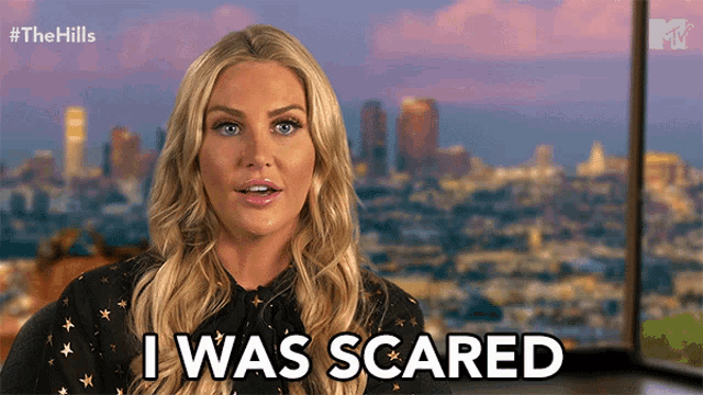 a woman says i was scared in front of a cityscape