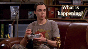 a man sits on a couch holding a tin foil container with the words " what is happening " written above him