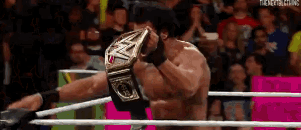 a man in a wrestling ring is wearing a wwe championship belt .
