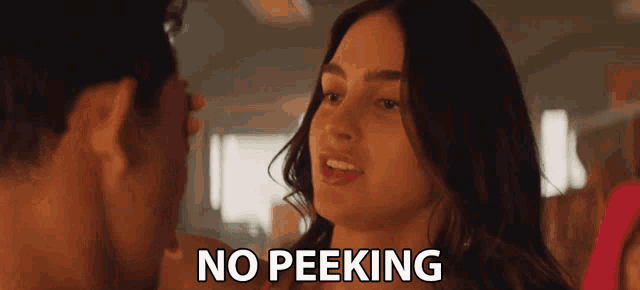a man and a woman are looking at each other and the words no peeking are visible