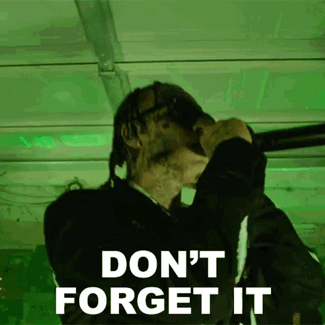 a man is singing into a microphone with the words `` do n't forget it '' written on it .