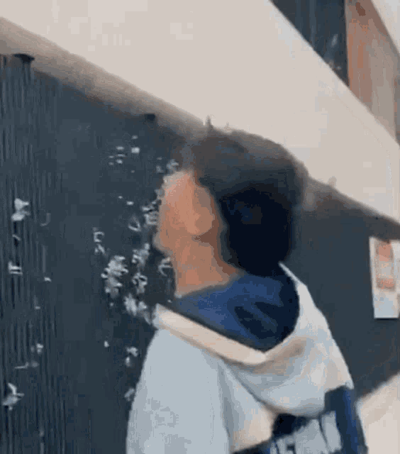 a man is standing in front of a blackboard with a lot of bubbles coming out of it .