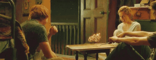 a group of people sitting around a table with a wand