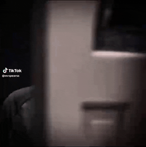 a person is standing in a dark room in front of a mirror .