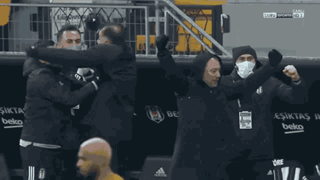 a group of men are standing on a soccer field wearing face masks