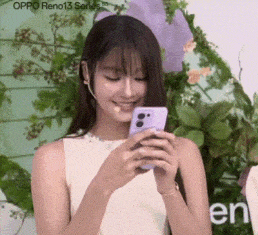 a woman is holding a cell phone in front of a sign that says oppo