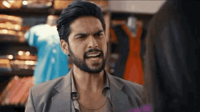 a man with a beard is making a funny face while talking to a woman
