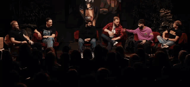 a group of men are sitting in front of a crowd and one of them is wearing a shirt that says ' swag '