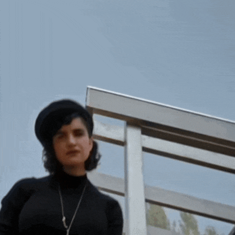 a woman wearing a black turtleneck sweater and a black hat