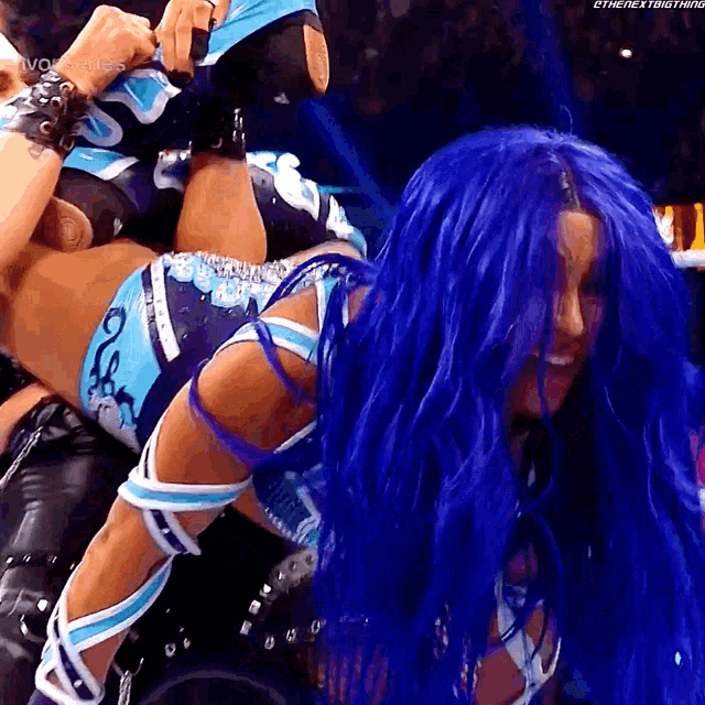 a woman with blue hair is being lifted up by a man
