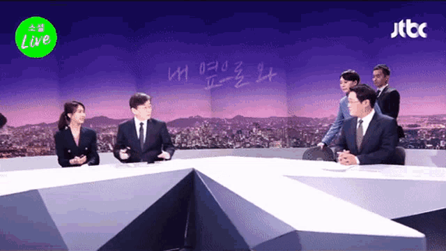 a group of people are sitting in front of a jtbc live sign