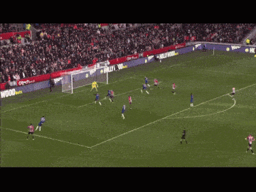 a soccer game is being played on a field with a hollywood advertisement on the sidelines