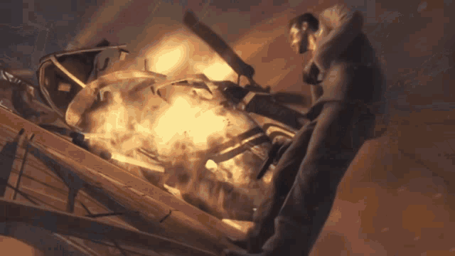 a man is standing on top of a burning vehicle with a fireball coming out of it ..