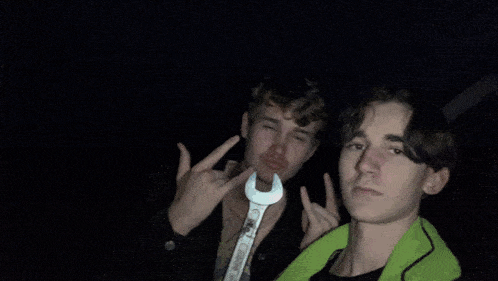 two boys are making funny faces and one has a green shirt on