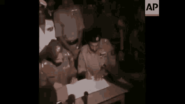 a blurry picture of a group of people standing around a table .