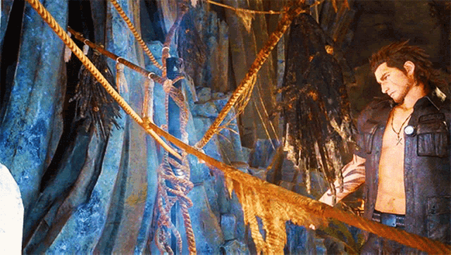 a man without a shirt is standing in a cave with ropes